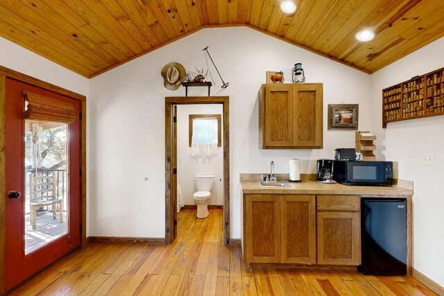 961 Buttercup Ln, Wimberley, TX 78676 - kitchen featuring a sink, black microwave, lofted ceiling, light wood-style floors, and wooden ceiling