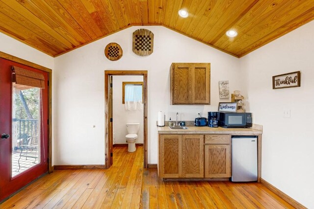 961 Buttercup Ln, Wimberley, TX 78676 - kitchen with stainless steel refrigerator, black microwave, wood ceiling, lofted ceiling, and light countertops
