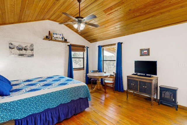 961 Buttercup Ln, Wimberley, TX 78676 - bedroom featuring wood ceiling, lofted ceiling, a wood stove, hardwood / wood-style flooring, and ceiling fan