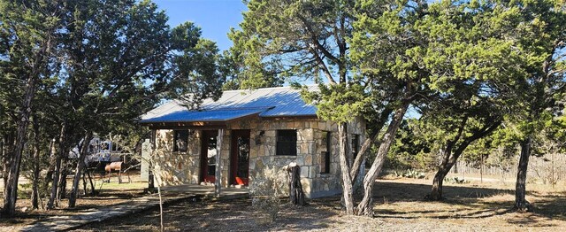 961 Buttercup Ln, Wimberley, TX 78676 - view of front facade with stone siding, metal roof, and an outbuilding