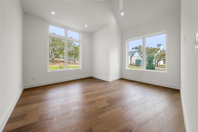 12120 Fitzhugh Pl, Dripping Springs, TX 78620 - empty room with healthy amount of natural light, wood-type flooring, baseboards, recessed lighting, and vaulted ceiling