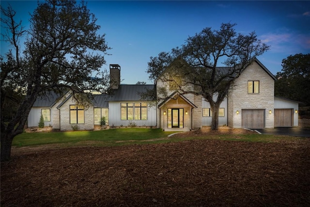 12120 Fitzhugh Pl, Dripping Springs, TX 78620 - modern farmhouse style home with a chimney, a standing seam roof, metal roof, a front lawn, and board and batten siding