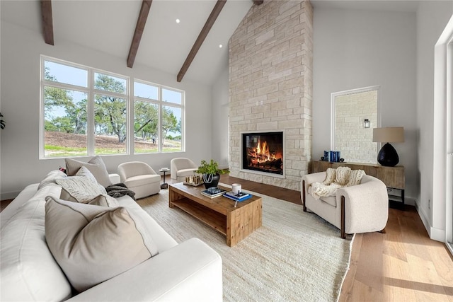 12120 Fitzhugh Pl, Dripping Springs, TX 78620 - living area with light wood-style floors, high vaulted ceiling, beamed ceiling, a fireplace, and baseboards