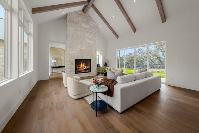 12120 Fitzhugh Pl, Dripping Springs, TX 78620 - living area featuring a stone fireplace, beamed ceiling, high vaulted ceiling, wood finished floors, and baseboards