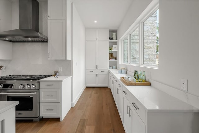 12120 Fitzhugh Pl, Dripping Springs, TX 78620 - kitchen featuring wall chimney exhaust hood, high end stainless steel range, white cabinetry, healthy amount of natural light, and recessed lighting