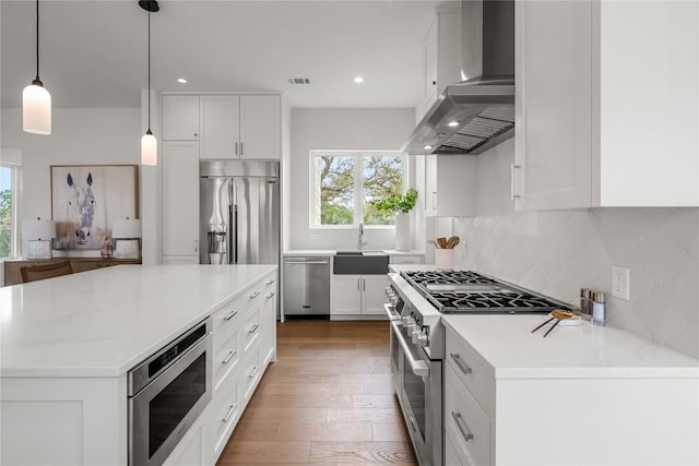 12120 Fitzhugh Pl, Dripping Springs, TX 78620 - kitchen with wall chimney exhaust hood, appliances with stainless steel finishes, plenty of natural light, a sink, and recessed lighting