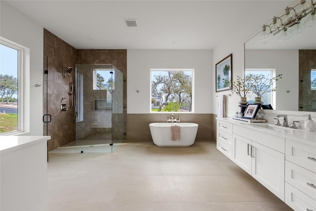 12120 Fitzhugh Pl, Dripping Springs, TX 78620 - full bathroom featuring a shower stall, vanity, a freestanding bath, tile patterned flooring, and tile walls