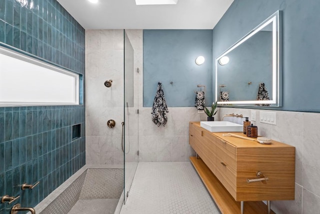 full bath featuring tile walls, vanity, and walk in shower