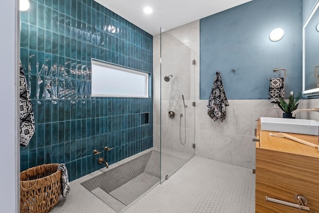 full bathroom featuring a walk in shower, vanity, and tile walls