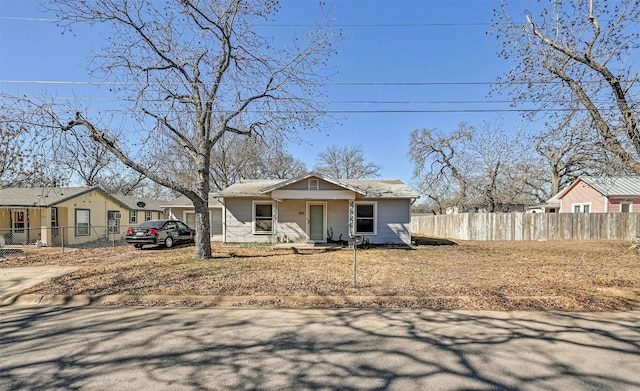 bungalow-style home with fence