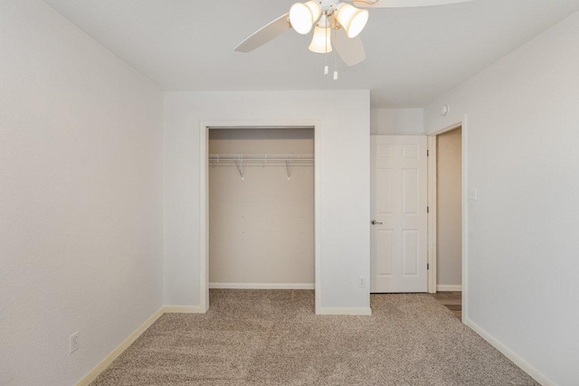 unfurnished bedroom with ceiling fan, a closet, carpet, and baseboards