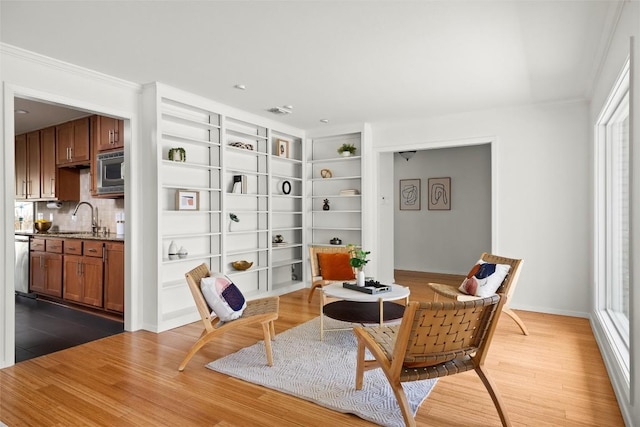 living area with visible vents, baseboards, and wood finished floors