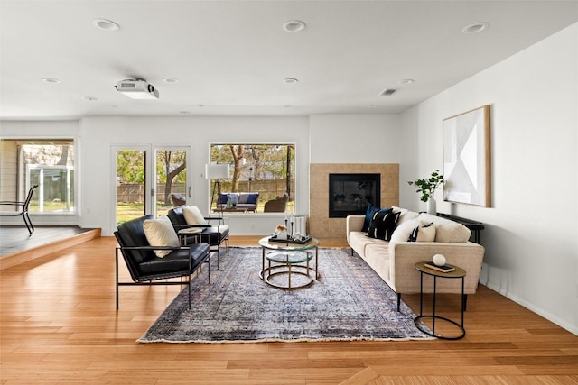 living room with baseboards, a fireplace, wood finished floors, and recessed lighting