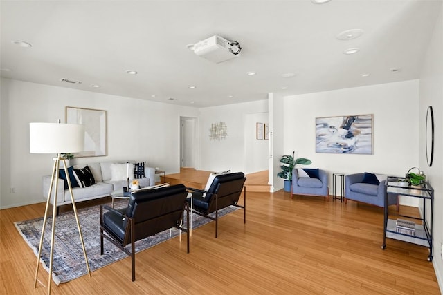 living room featuring light wood-style flooring, visible vents, and recessed lighting