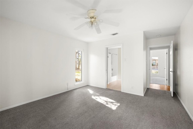 unfurnished bedroom featuring carpet floors, visible vents, baseboards, and a ceiling fan