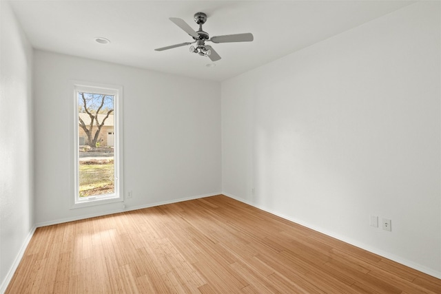 unfurnished room with baseboards, ceiling fan, and light wood finished floors