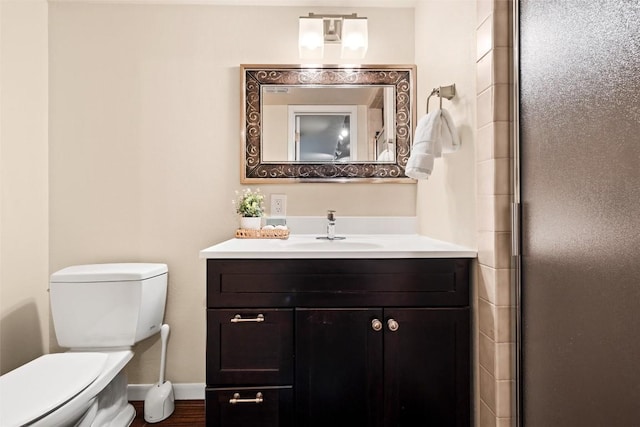 bathroom featuring an enclosed shower, vanity, toilet, and baseboards