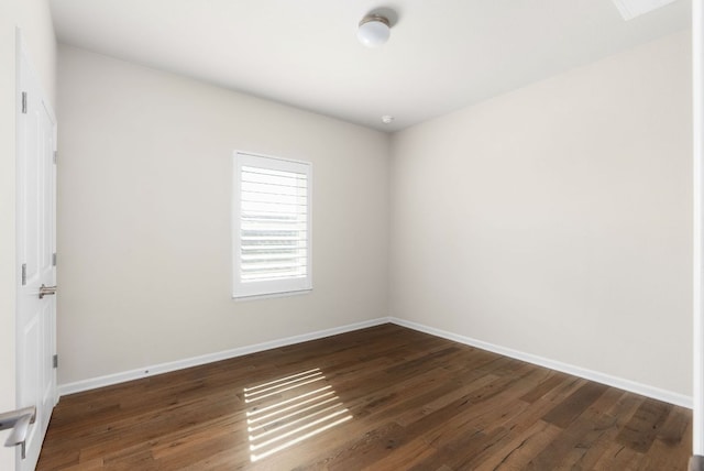 empty room featuring baseboards and wood finished floors