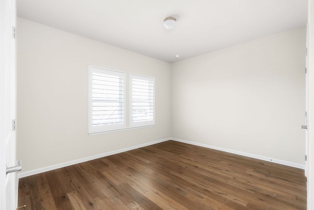 empty room featuring wood-type flooring and baseboards