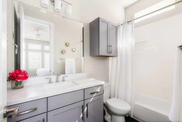 ensuite bathroom featuring ceiling fan, connected bathroom, toilet, vanity, and shower / bath combination with curtain