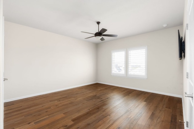 unfurnished room featuring dark wood-style floors, ceiling fan, and baseboards