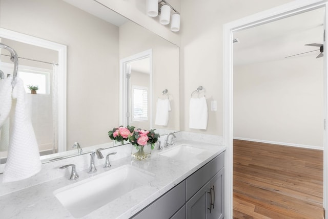 full bath with a healthy amount of sunlight, a sink, and wood finished floors