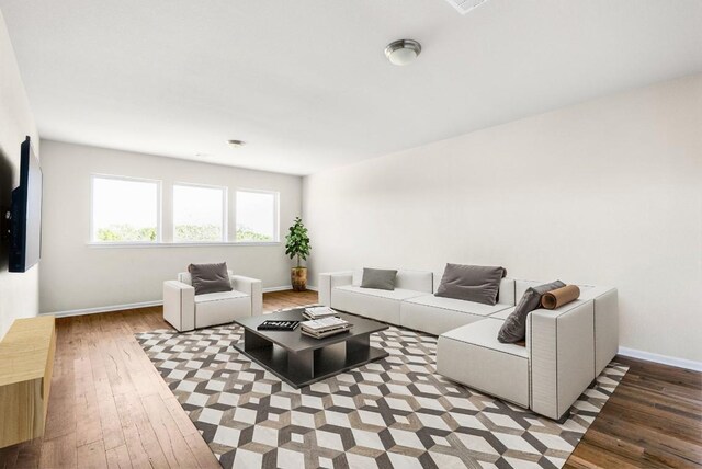 living area with wood-type flooring and baseboards