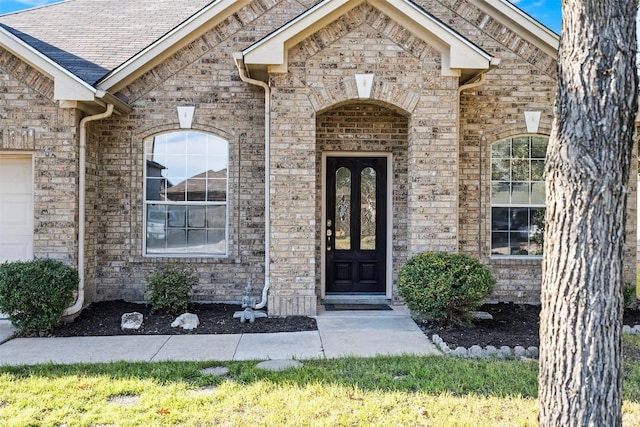 entrance to property with brick siding and roof with shingles