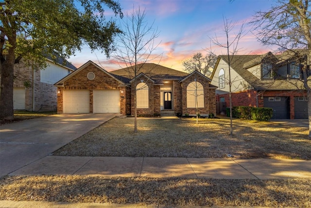 view of front of home with driveway, brick siding, and an attached garage