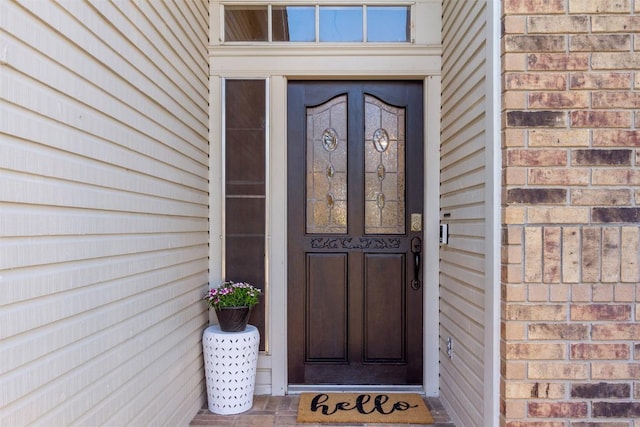 property entrance featuring brick siding