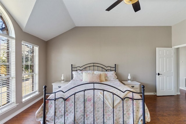 bedroom with lofted ceiling, a ceiling fan, visible vents, baseboards, and dark wood-style floors