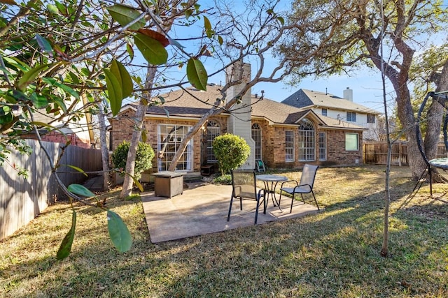 exterior space featuring a patio area, brick siding, a yard, and a fenced backyard