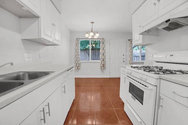 kitchen featuring a sink, light countertops, white range with gas stovetop, under cabinet range hood, and dark tile patterned flooring