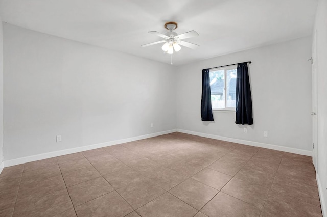 spare room featuring tile patterned floors, ceiling fan, and baseboards