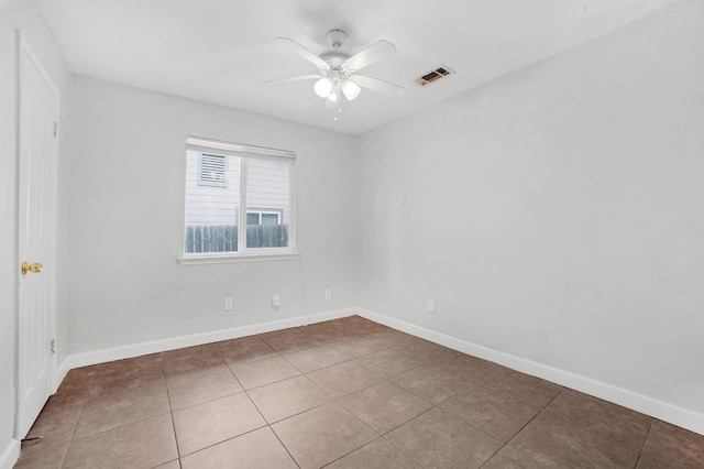 empty room with tile patterned floors, ceiling fan, baseboards, and visible vents