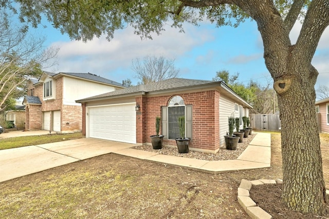 view of home's exterior with a garage, concrete driveway, roof with shingles, fence, and brick siding