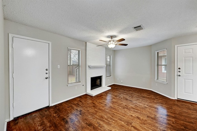 1807 Hollow Tree Blvd, Round Rock, TX 78681 - unfurnished living room with plenty of natural light, wood finished floors, ceiling fan, a textured ceiling, and a fireplace
