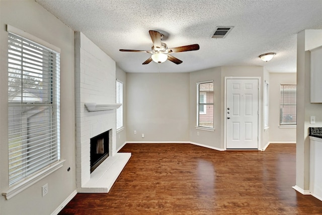 1807 Hollow Tree Blvd, Round Rock, TX 78681 - unfurnished living room with a ceiling fan, a fireplace, wood finished floors, and a textured ceiling