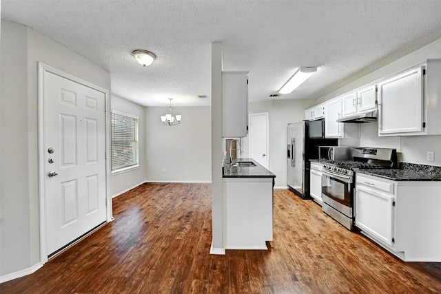 1807 Hollow Tree Blvd, Round Rock, TX 78681 - kitchen with stainless steel appliances, a chandelier, dark wood finished floors, white cabinetry, and a textured ceiling