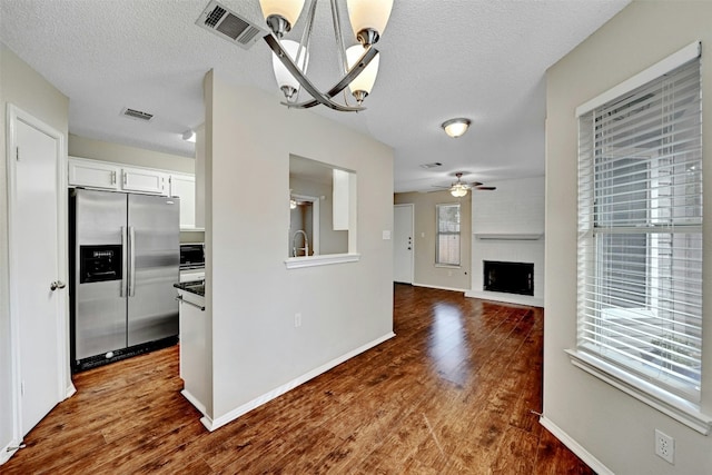 1807 Hollow Tree Blvd, Round Rock, TX 78681 - kitchen featuring stainless steel fridge, a ceiling fan, a textured ceiling, white cabinetry, and dark wood-style floors