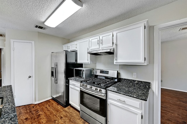 1807 Hollow Tree Blvd, Round Rock, TX 78681 - kitchen featuring stainless steel appliances, under cabinet range hood, a textured ceiling, dark wood-style flooring, and white cabinetry