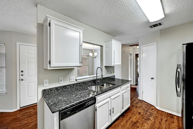 1807 Hollow Tree Blvd, Round Rock, TX 78681 - kitchen with stainless steel appliances, dark wood-style flooring, white cabinets, a textured ceiling, and dark stone counters