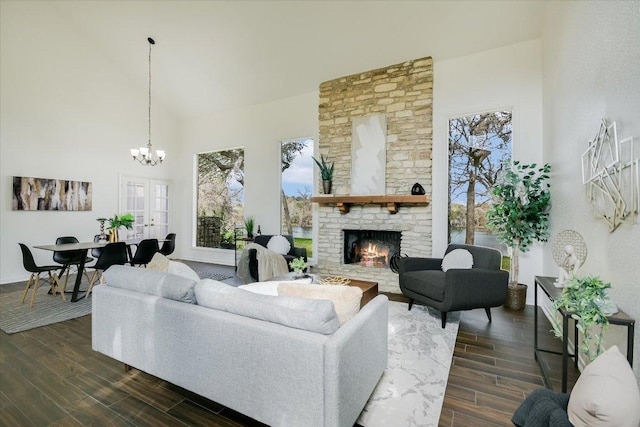 living room with high vaulted ceiling, a fireplace, an inviting chandelier, and wood tiled floor