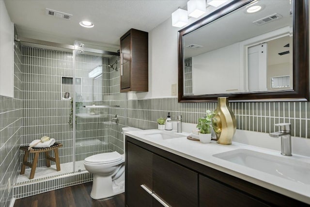 bathroom featuring tile walls, visible vents, and a sink