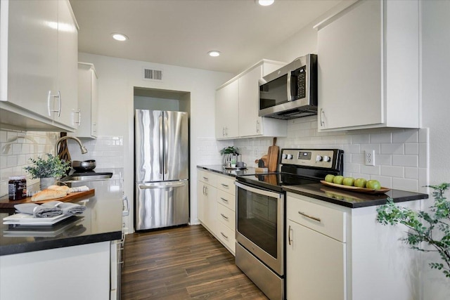 kitchen featuring dark countertops, visible vents, stainless steel appliances, and a sink