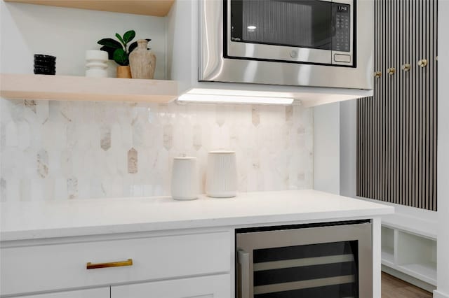 360 Judy Dr, Dripping Springs, TX 78620 - interior details with beverage cooler, stainless steel microwave, white cabinets, light countertops, and tasteful backsplash