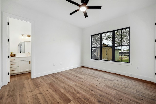 360 Judy Dr, Dripping Springs, TX 78620 - unfurnished bedroom with light wood finished floors, connected bathroom, baseboards, and a sink