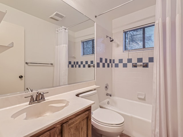 full bath featuring toilet, vanity, visible vents, and shower / tub combo with curtain