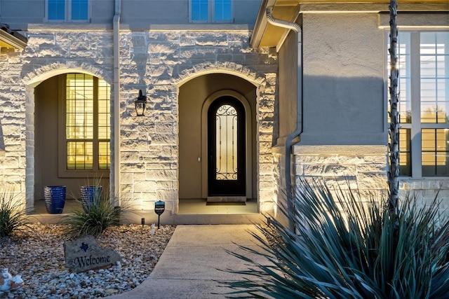 property entrance with stone siding and stucco siding