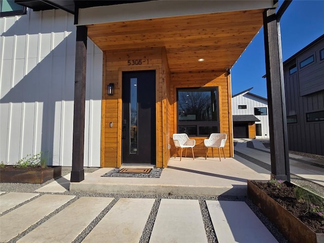 view of exterior entry featuring a porch and board and batten siding